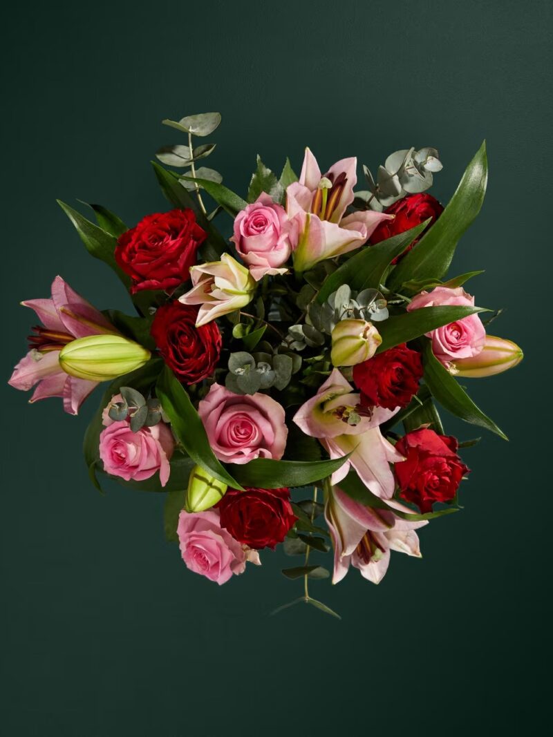 Rozā lilijas un sarkanās rozes ziedu pušķis