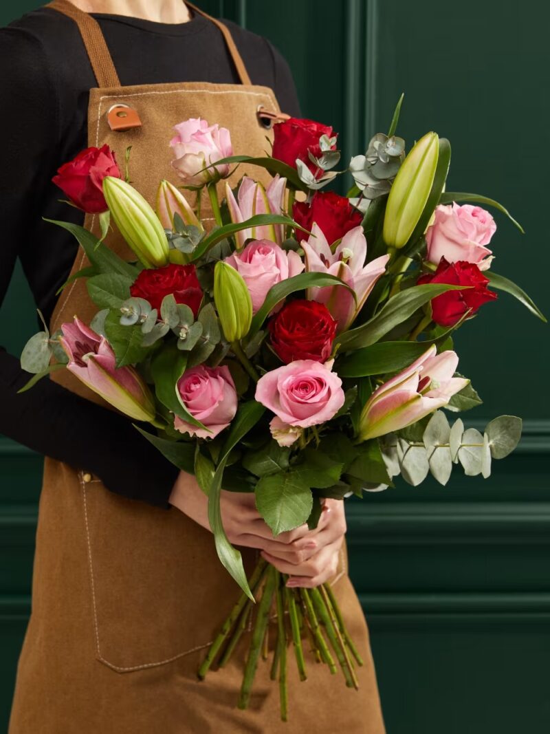 Rozā lilijas un sarkanās rozes ziedu pušķis